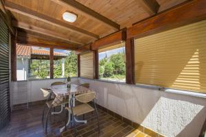 eine Veranda mit einem Tisch und einigen Fenstern in der Unterkunft Apartment Vili in Pinezici