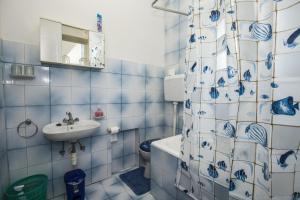 ein blau-weißes Bad mit einem WC und einem Waschbecken in der Unterkunft Apartment Vili in Pinezici