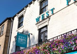 a sign on the side of a building with flowers at The West Park Hotel in Harrogate