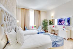プロブディフにあるRamada by Wyndham Plovdiv Trimontiumのベッド2台とデスクが備わるホテルルームです。