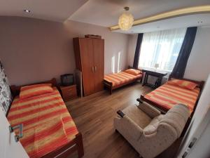 a room with two beds and a couch and a bed at Apartments "Predah kod Baraća" in Niš