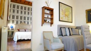 a living room with a bed and a chair at Sprone Apartment in Florence