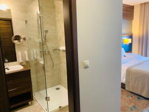 łazienka z prysznicem, umywalką i łóżkiem w obiekcie Barack Thermal Hotel and Spa w mieście Tiszakécske