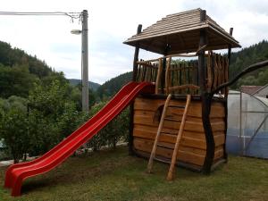 einen Spielplatz mit einer roten Rutsche und einem Pavillon in der Unterkunft Penzion Apartmány Bečov in Bečov nad Teplou