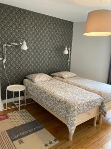 a small bedroom with two beds and a lamp at L'escale Granvillaise in Granville
