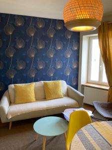 a living room with a couch and a blue wall at L'escale Granvillaise in Granville