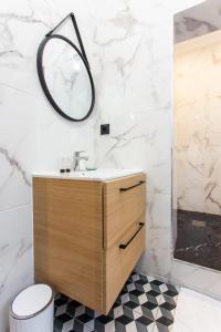 La salle de bains est pourvue d'un lavabo et d'un miroir mural. dans l'établissement CMG Saint Antoine - Bastille 9, à Paris