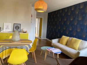 a living room with a couch and a table at L'escale Granvillaise in Granville