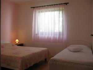 a bedroom with two beds and a window at Apartments Pende 3122 in Banjol