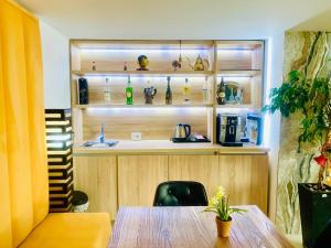 a room with a table and a kitchen with shelves at Park Hotel Tirana in Tirana