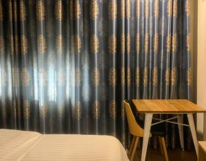 a room with a bed and a table and a curtain at Park Hotel Tirana in Tirana