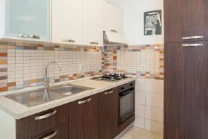 a kitchen with a sink and a stove at Apartments Leut 80m from the Sea in Podgora