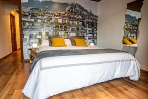 a bedroom with a large white bed with yellow pillows at LA CASETA Turismo Rural in Morella