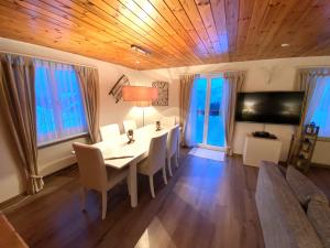 a dining room with a table and chairs and a tv at Haus Trynsch Flumserberg in Flumserberg