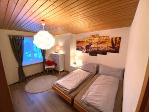 Schlafzimmer mit einem Bett mit Holzdecke in der Unterkunft Haus Trynsch Flumserberg in Flumserberg