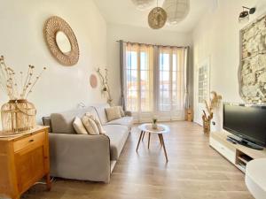 een woonkamer met een bank en een tv bij Le St Roch 2 in Menton