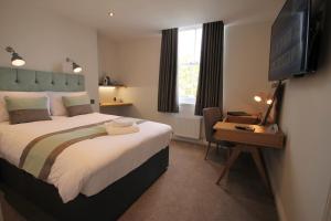 a hotel room with a bed and a television at Andover House Hotel & Restaurant - Adults only in Great Yarmouth
