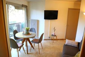 ein Wohnzimmer mit einem Tisch und Stühlen in der Unterkunft Charmant appartement dans résidence avec piscine in Mandelieu-la-Napoule