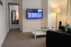 a living room filled with furniture and a tv at Andover House Hotel & Restaurant - Adults only in Great Yarmouth
