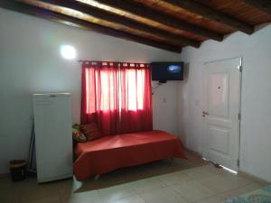 een kamer met een rode bank voor een raam bij El diquecito monoambiente in Casa Bamba