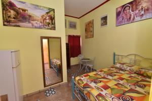Schlafzimmer mit einem Bett und einem Spiegel in der Unterkunft Corinne Hostel in Eilat
