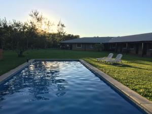a swimming pool with two chairs in a yard at Iberá Porá in Colonia Carlos Pellegrini
