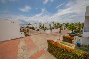 a parking lot with white buildings and flowers at Casa LUNA in Mezcales