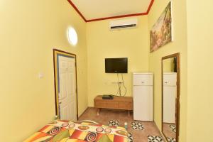 ein Schlafzimmer mit einem Bett und einem TV an der Wand in der Unterkunft Corinne Hostel in Eilat