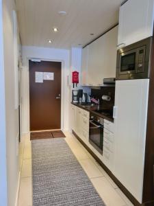 eine Küche mit einer Mikrowelle und einer Tür in der Unterkunft LeviBooking LeviStar II apt 309 in Levi