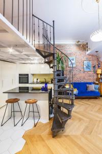 a kitchen and living room with a spiral staircase at Retro Apartment Old Town in Wrocław