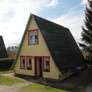 ein gelbes Haus mit schwarzem Dach in der Unterkunft Harzer Finnhütte in Elbingerode