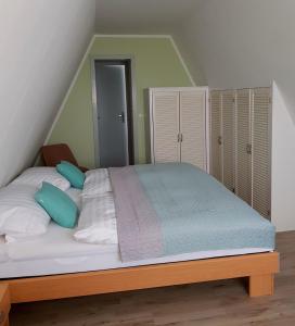 1 dormitorio con 1 cama grande con almohadas blancas y azules en Harzer Finnhütte en Elbingerode