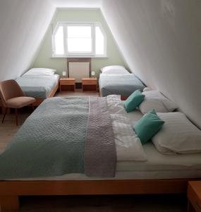 1 dormitorio en el ático con 2 camas y ventana en Harzer Finnhütte en Elbingerode