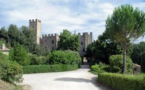 a castle with two towers in the middle of a driveway at Castello di Montalto in Castelnuovo Berardenga