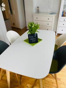 a white dining room table with a plant on it at Ferienwohnung Mönch49 in Stralsund