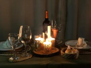 a table with a bottle of wine and glasses and candles at Iberá Porá in Colonia Carlos Pellegrini