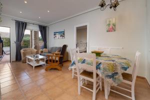 ein Esszimmer und ein Wohnzimmer mit Tisch und Stühlen in der Unterkunft Homes of Spain, Al Andalus Residencial Apartamento P bajo con WIFI in Playas de Vera