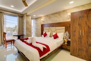 a bedroom with a large bed with red pillows at Hotel Samaira Residency,Dombivali in Dive