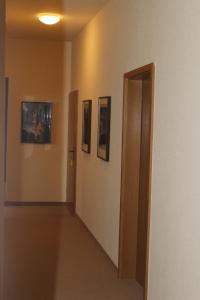un couloir avec trois photos sur les murs dans l'établissement Hotel Zum Gondoliere, à Oranienbaum-Wörlitz