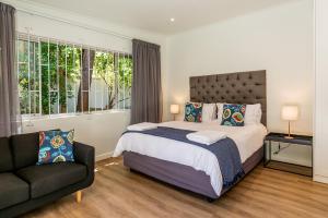 a bedroom with a large bed and a couch at Oak Manor in Cape Town