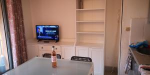 ヴィルヌーヴ・ルベにあるRésidence Cap Azur Appartement 229のテーブル、テレビ、椅子が備わる客室です。
