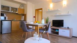 een keuken en een woonkamer met een tafel en stoelen bij Бяла Резидънс - Byala Residence Apart Complex in Byala