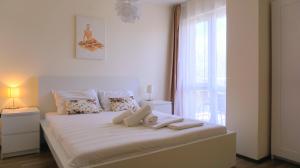 een slaapkamer met een groot wit bed en een raam bij Бяла Резидънс - Byala Residence Apart Complex in Byala