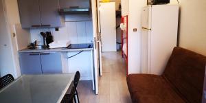 a small kitchen with a refrigerator and a couch at Résidence Cap Azur Appartement 229 in Villeneuve-Loubet