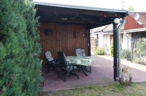 un patio avec une table et des chaises sous un pavillon dans l'établissement Fewo-Sossna, à Brandebourg-sur-la-Havel