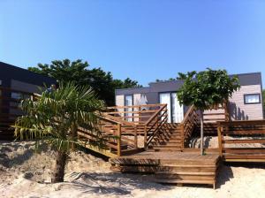 a house on the beach with a wooden deck at Le Village Vacances de Mimizan Plage in Mimizan-Plage