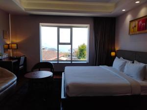 een hotelkamer met een bed en een raam bij The Hamuse Luxury hotel in Kodaikānāl