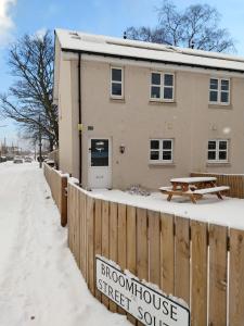 a building with a sign in the snow at BroomHouse HomeStay in Edinburgh