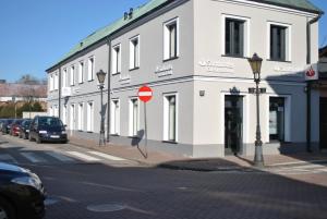 biały budynek po stronie ulicy w obiekcie Apartamenty Łowicz w Łowiczu