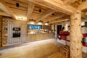 a large kitchen with wooden floors and wooden ceilings at ZRUB MARTINKY in Demanovska Dolina